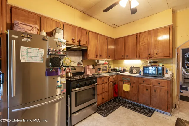a kitchen with stainless steel appliances granite countertop a refrigerator a stove and a sink with cabinets