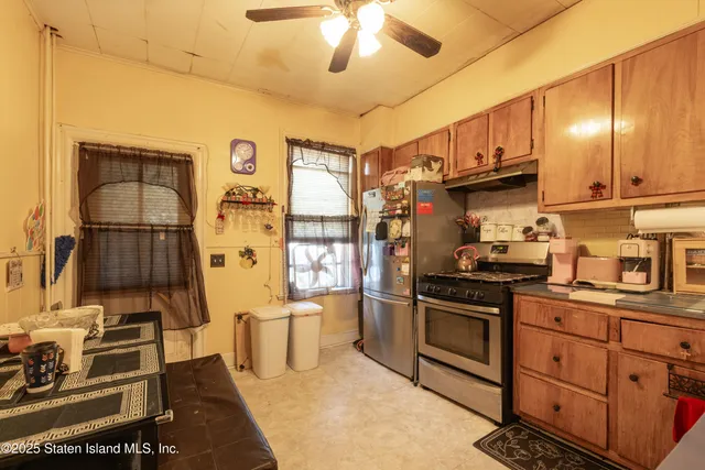 a kitchen with stainless steel appliances granite countertop a stove refrigerator and cabinets