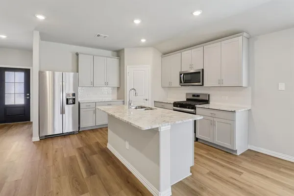 a kitchen with white cabinets and stainless steel appliances