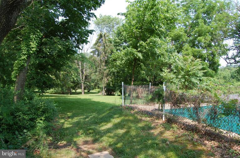 13508 Motters Station Road Rocky Ridge, MD 21778 - Photo 12 of 19 a backyard of a house with plants and large trees