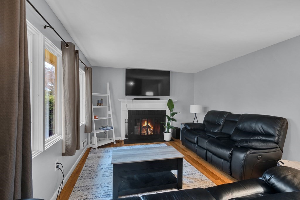 97 Hadley Street Springfield, MA 01118 - Photo 15 of 37 a living room with furniture a fireplace and a flat screen tv
