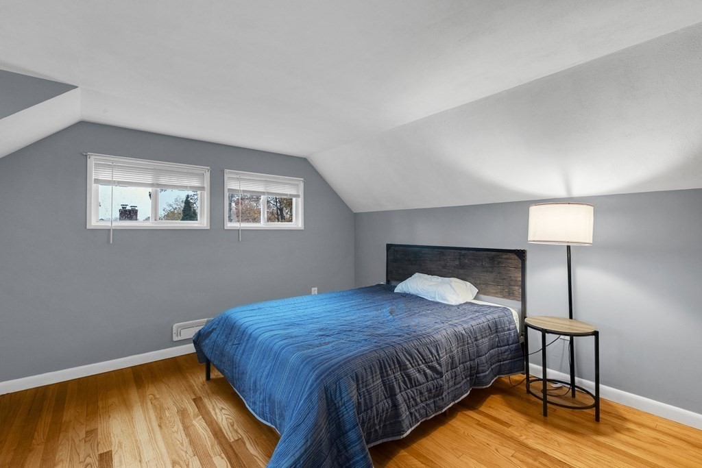 97 Hadley Street Springfield, MA 01118 - Photo 29 of 37 a spacious bedroom with a bed and a wooden floor