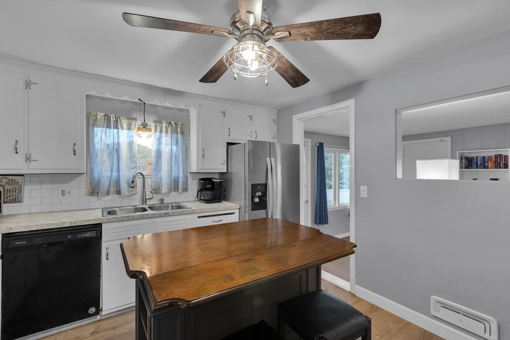 97 Hadley Street Springfield, MA 01118 - Photo 4 of 37 a kitchen with stainless steel appliances granite countertop a dining table chairs and a refrigerator
