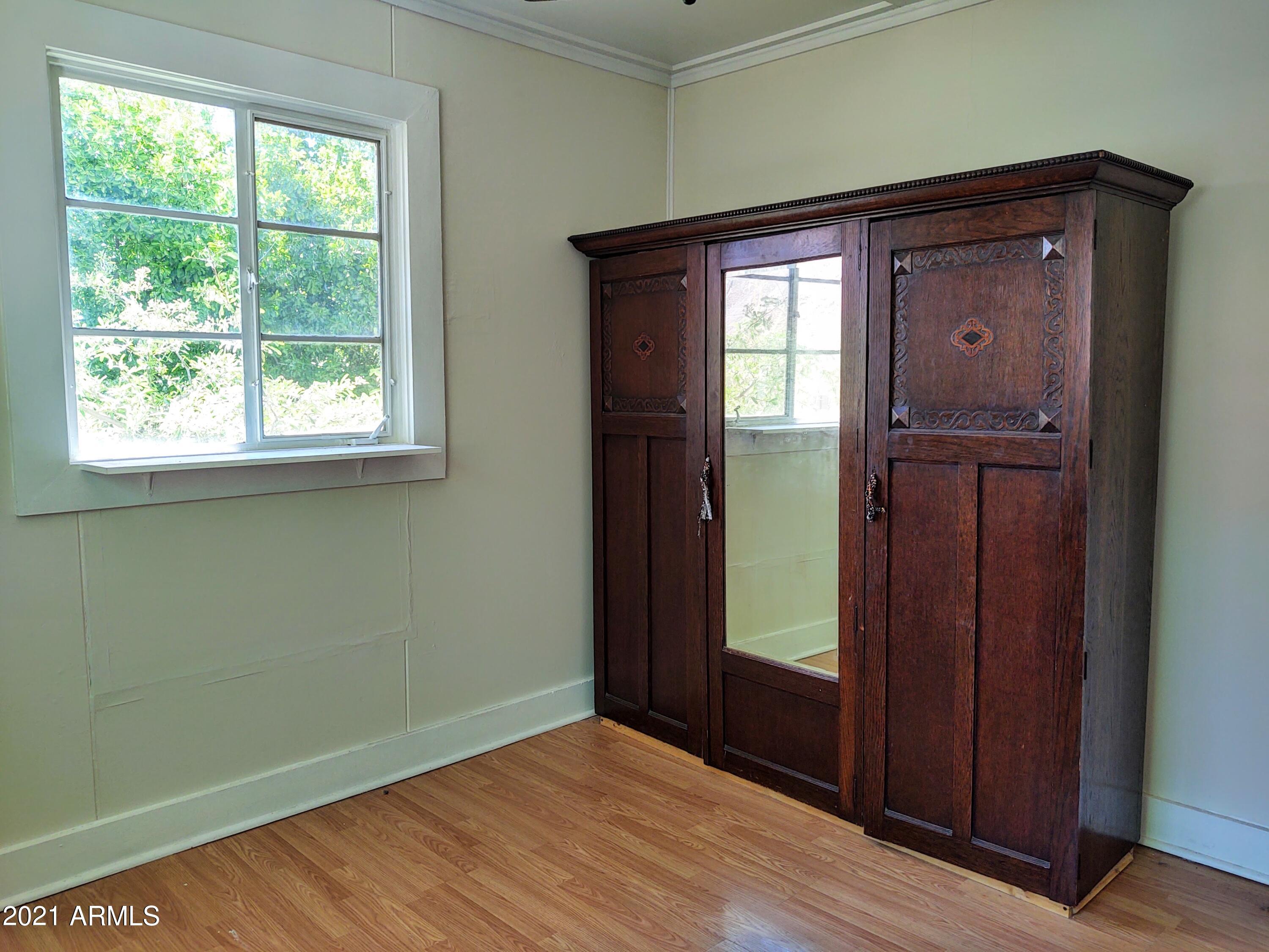 32 Old Douglas Road Bisbee, AZ 85603 - Photo 9 of 16 an empty room with wooden floor closet and windows