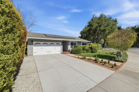 front view of a house with a yard and potted plants
