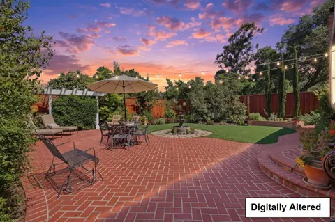 a view of a house with backyard and sitting area
