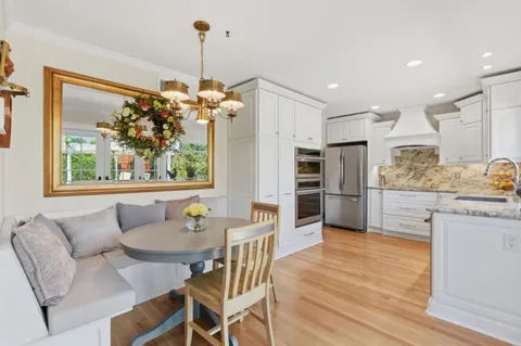 a dining room filled a chandelier a glass table and chairs