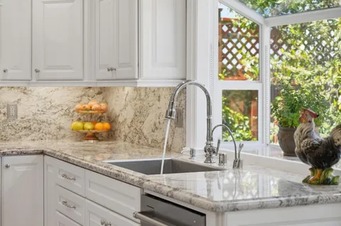 a kitchen with granite countertop a sink a window and counter space