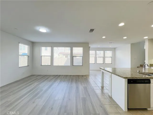 a kitchen with stainless steel appliances granite countertop a sink cabinets and wooden floor
