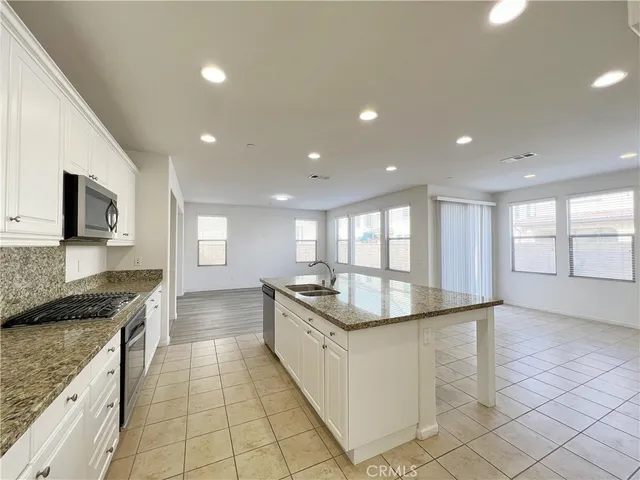 a kitchen with stainless steel appliances granite countertop a sink and a stove top oven