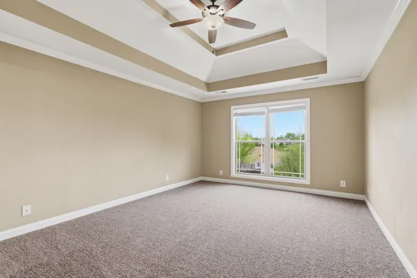 an empty room with a ceiling fan and window