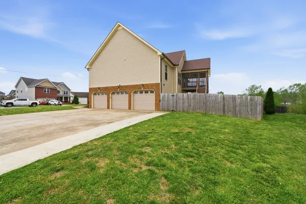 a view of house with backyard and a garden
