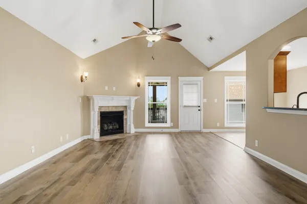 a view of an empty room with a fireplace and a window