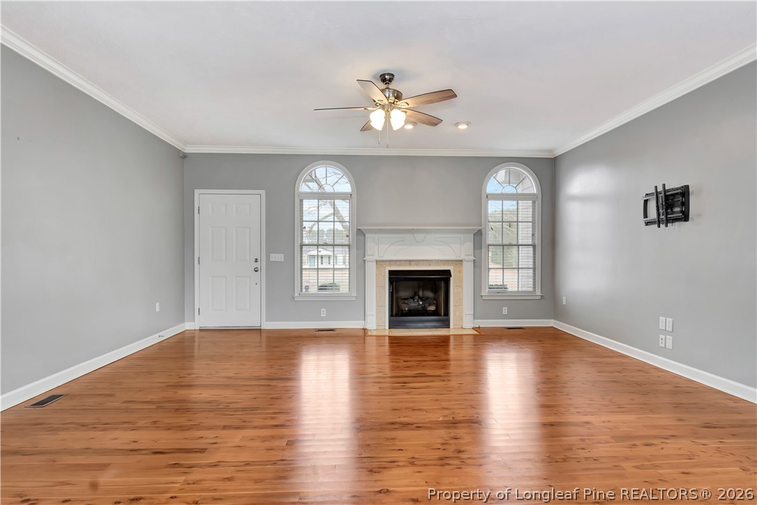 143 Pridgen Road Lumberton, NC 28358 - Photo 8 of 37 an empty room with wooden floor fireplace and windows