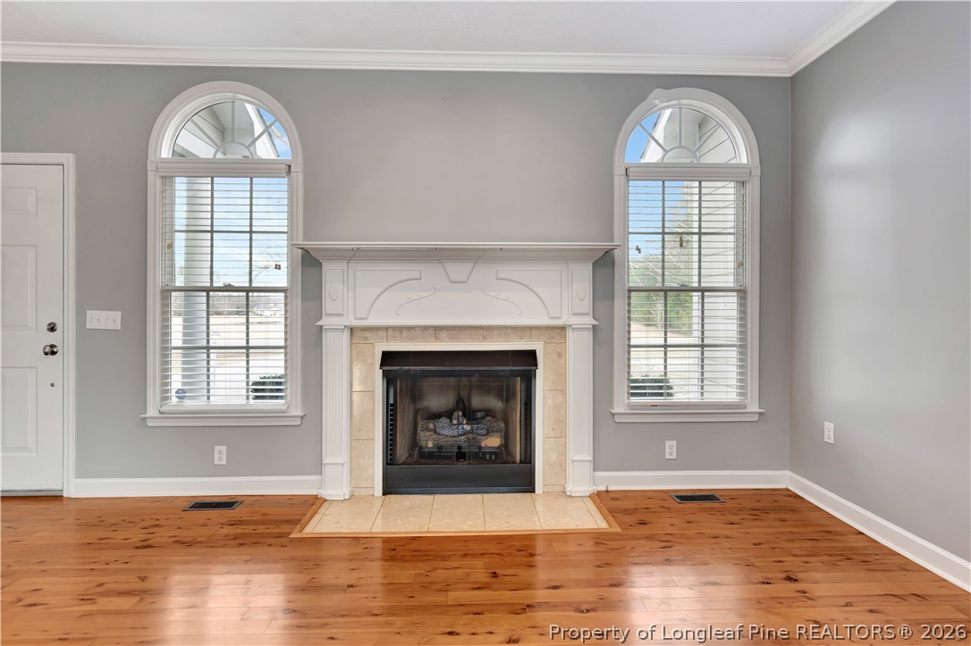 143 Pridgen Road Lumberton, NC 28358 - Photo 9 of 37 an empty room with wooden floor a fireplace and windows