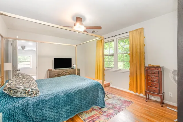 a bedroom with a bed and wooden floor
