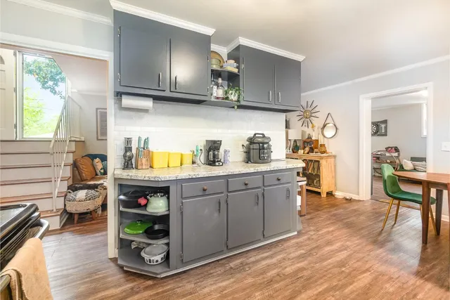 a kitchen with stainless steel appliances granite countertop a sink a stove and wooden floors