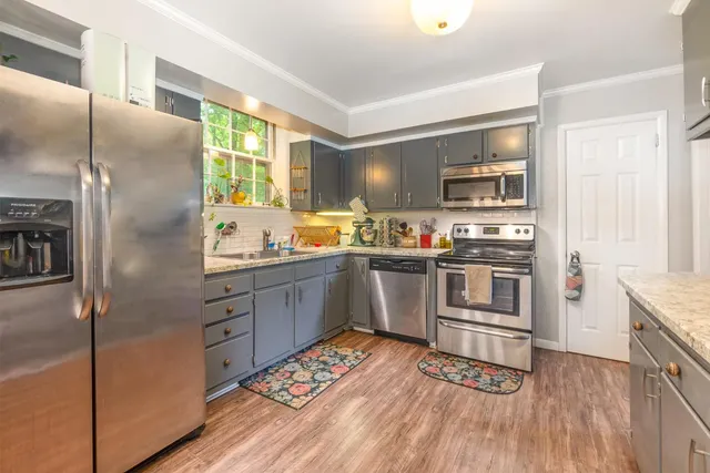 a kitchen with stainless steel appliances a refrigerator sink and microwave