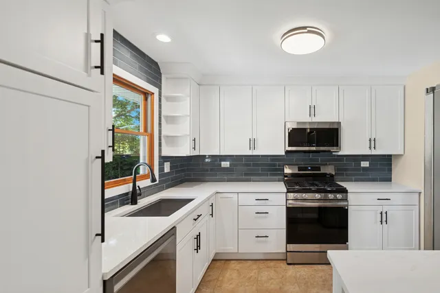 a kitchen with stainless steel appliances a stove a sink and a refrigerator