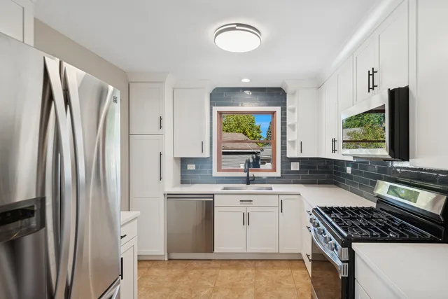 a kitchen with stainless steel appliances a refrigerator sink and stove