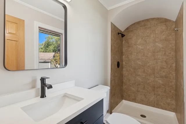 a bathroom with a sink a toilet and shower