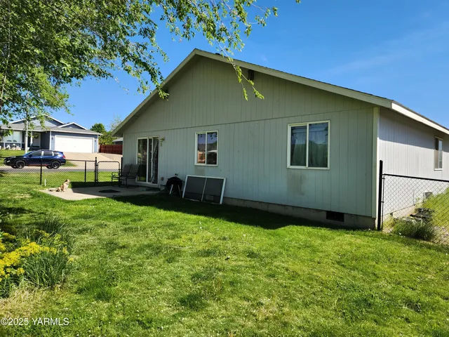 a backyard of a house with table and chairs