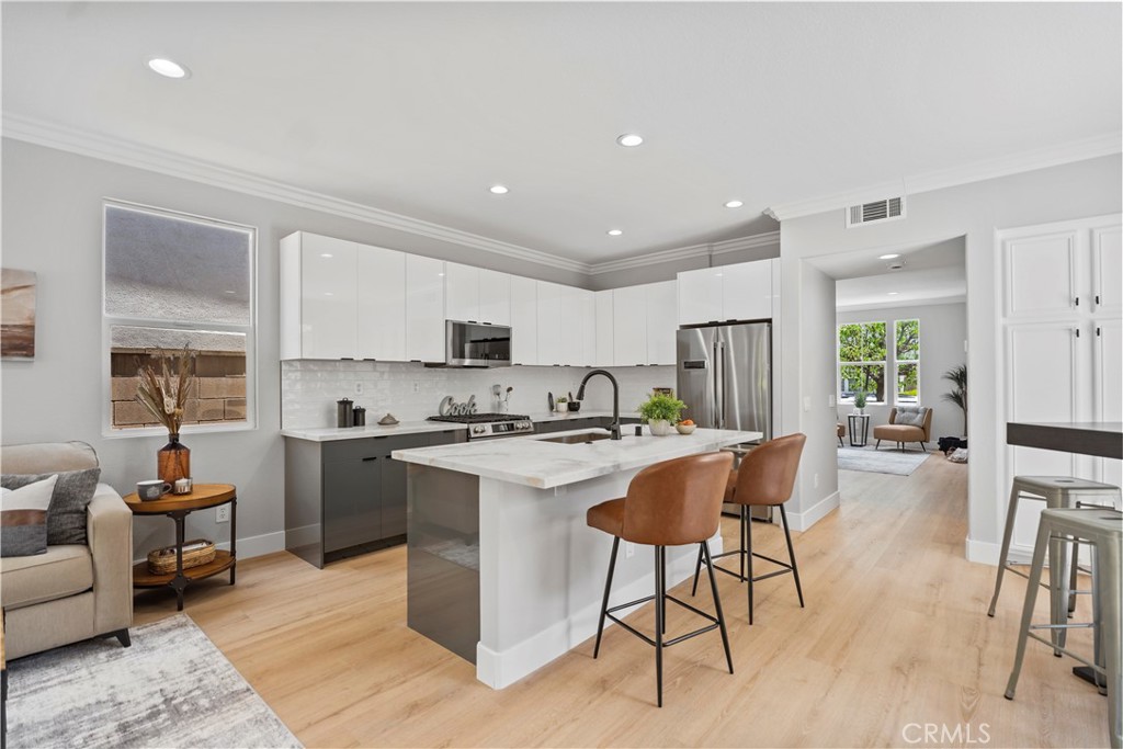 2129 Studio Drive Brea, CA 92821 - Photo 16 of 43 a kitchen with stainless steel appliances kitchen island granite countertop a stove a sink a dining table and chairs