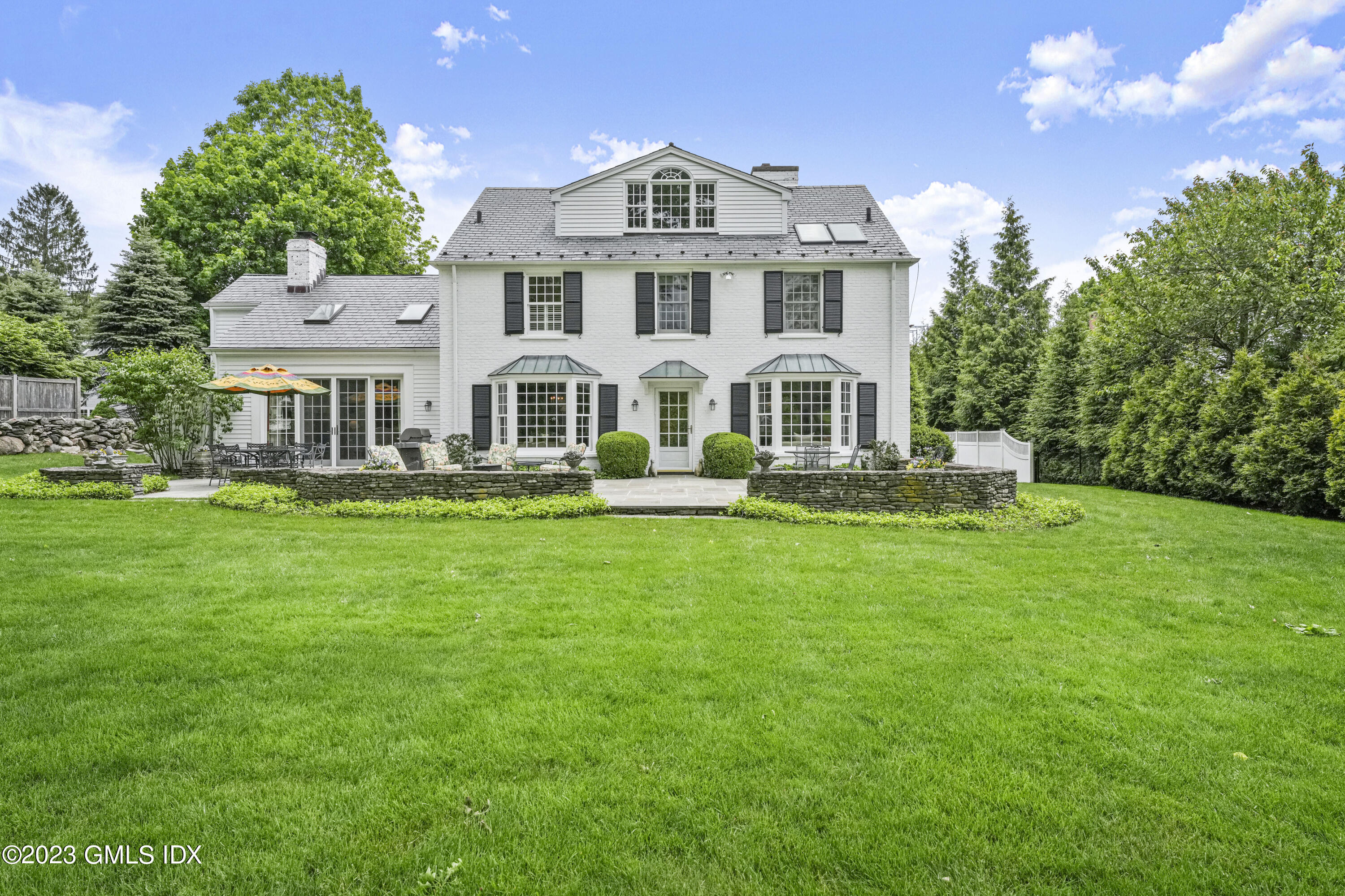 160 Stanwich Road Greenwich, CT 06830 - Photo 2 of 11 a front view of a house with a yard table and chairs