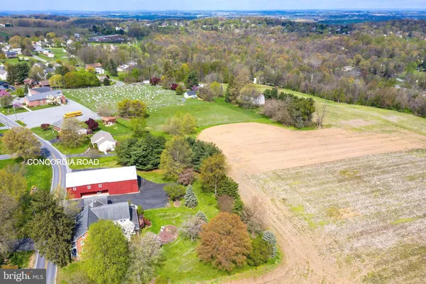 an aerial view of residential houses with outdoor space and trees