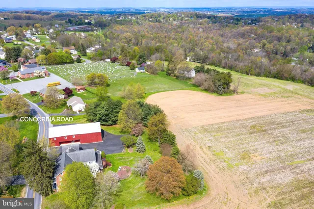 an aerial view of residential houses with outdoor space and trees