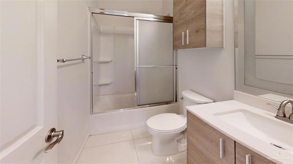 5608 Nightingale Avenue, Unit 2 Mission, TX 78573 - Photo 7 of 9 a bathroom with a granite countertop sink toilet and shower