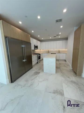 a view of a refrigerator with white cabinets
