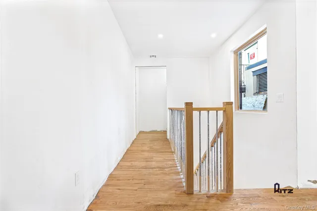 a view of a hallway with wooden floor and staircase