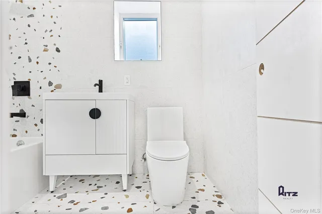 a white toilet sitting next to a bathroom sink and a shower