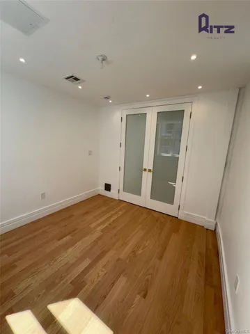 an empty room with wooden floor and natural light