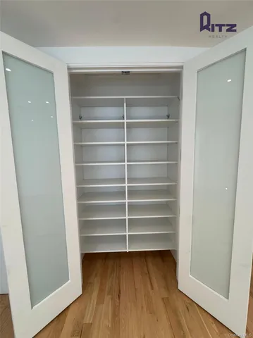 an empty room with wooden floor and natural light