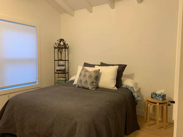 a bed sitting in a bedroom next to a lamp