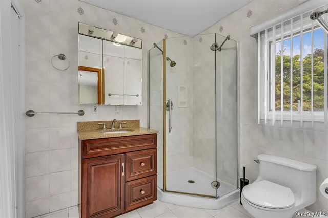 a bathroom with a granite countertop sink a toilet and shower