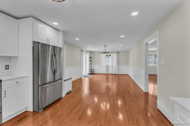 a view of empty room with wooden floor and electronic appliances