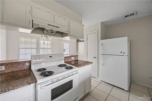 a kitchen with white cabinets and white appliances