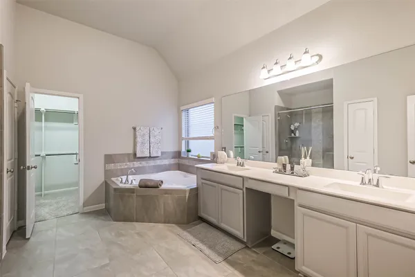 a large bathroom with a double vanity sink mirror and bathtub