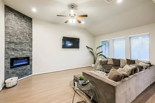 a living room with furniture and a wooden floor