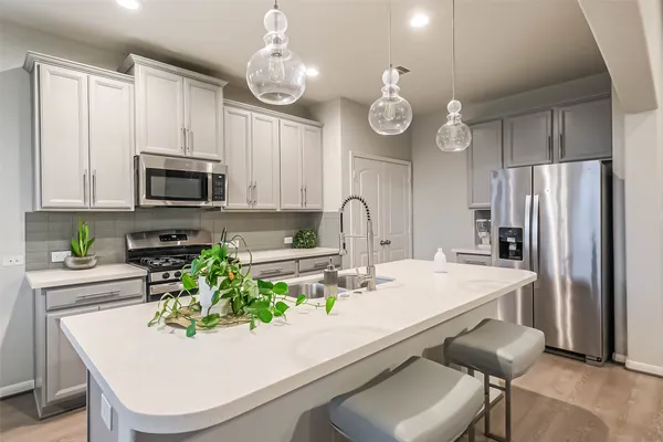 a kitchen with a sink a microwave a stove and refrigerator