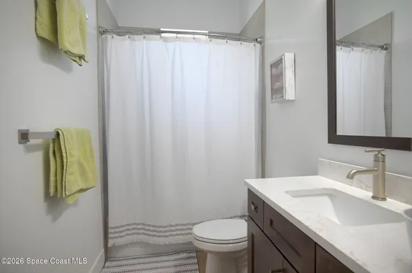 a bathroom with a granite countertop sink toilet and a mirror