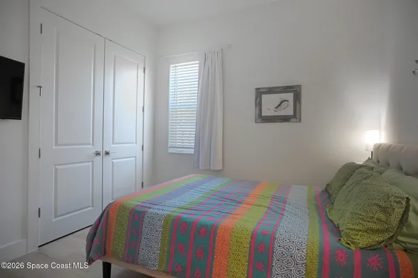 a bedroom with a bed and teddy bear on the dresser