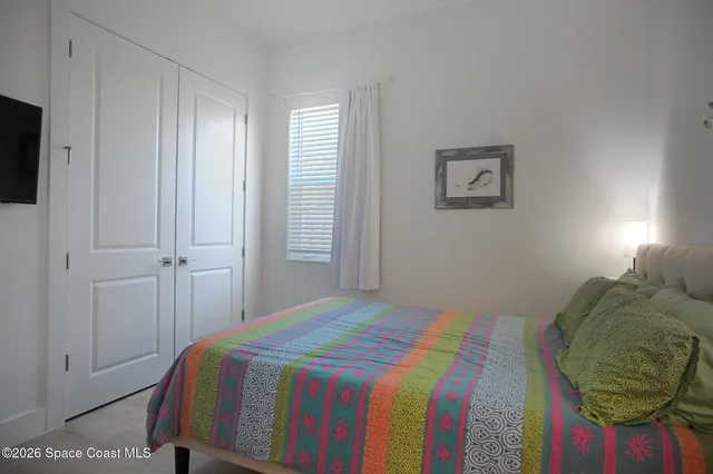 a bedroom with a bed and teddy bear on the dresser