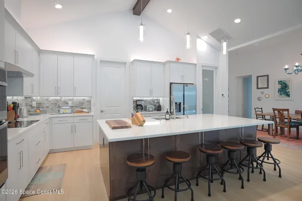 a kitchen with a sink stools a counter space and cabinets