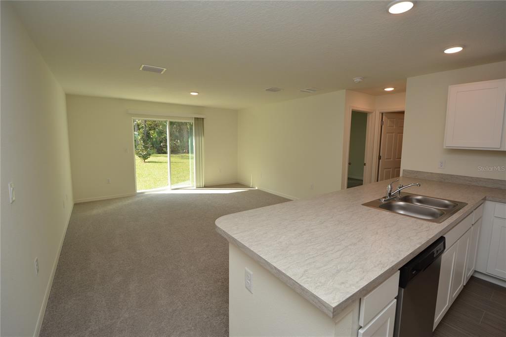 8 Sea Flower Path Palm Coast, FL 32164 - Photo 11 of 30 a kitchen with a stove a sink a refrigerator and a counter top space