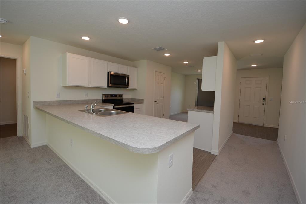 8 Sea Flower Path Palm Coast, FL 32164 - Photo 6 of 30 a kitchen with a sink and a refrigerator