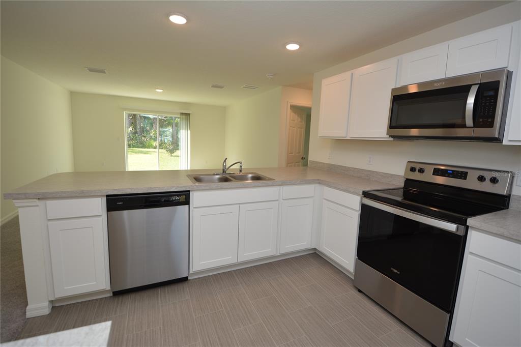 8 Sea Flower Path Palm Coast, FL 32164 - Photo 8 of 30 a kitchen with stainless steel appliances white cabinets and a sink